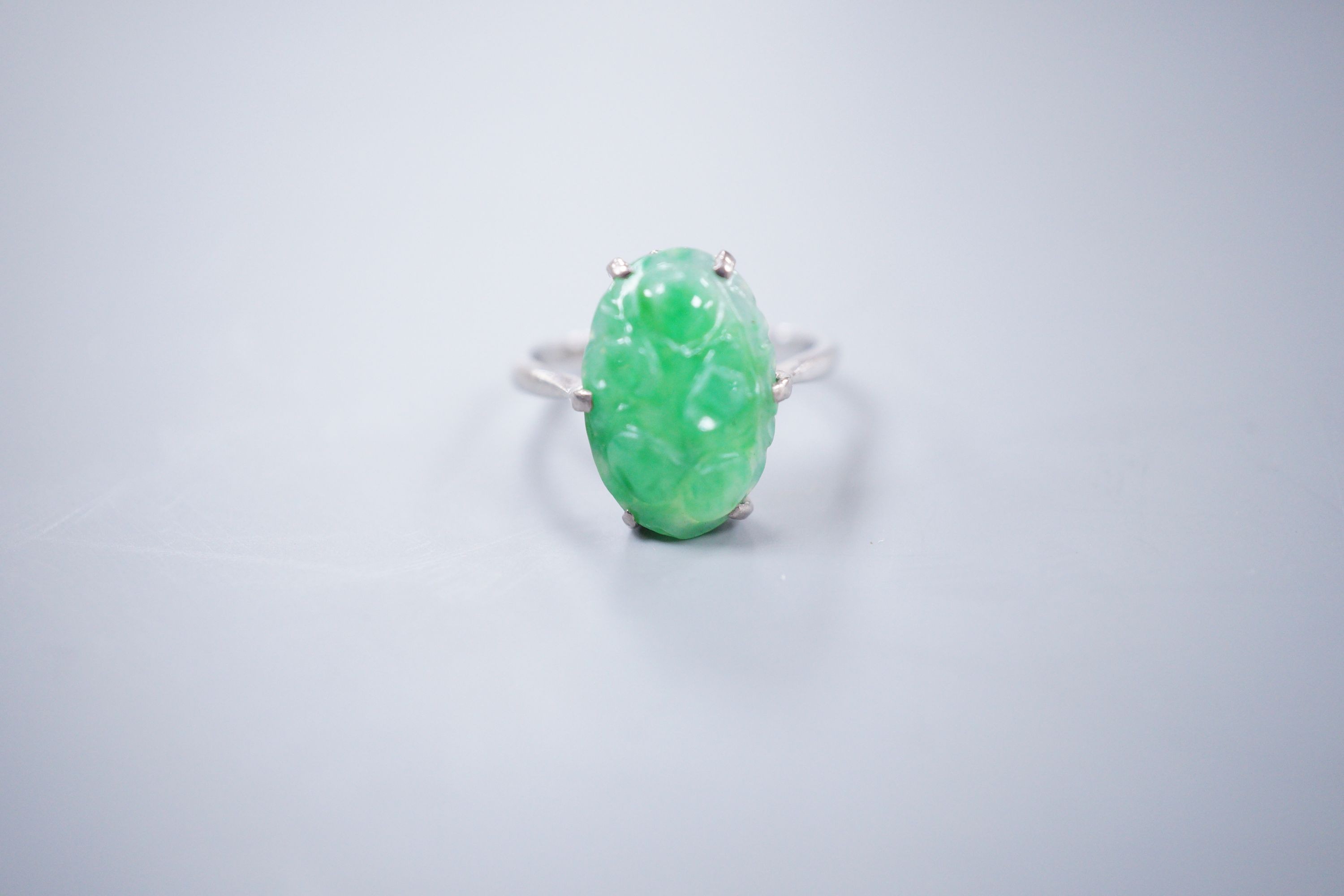 An 18ct white gold and carved jade dress ring, size M, gross 3.9 grams